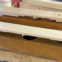 Woodworking bench with cutout slot and stacked wooden planks on top